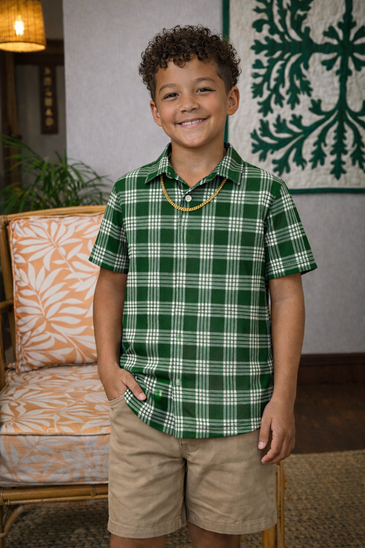 Child wearing a green plaid shirt and beige shorts in a home setting.